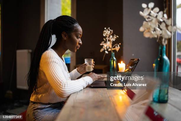 woman at coffee shop working on laptop - berlin cafe fotografías e imágenes de stock