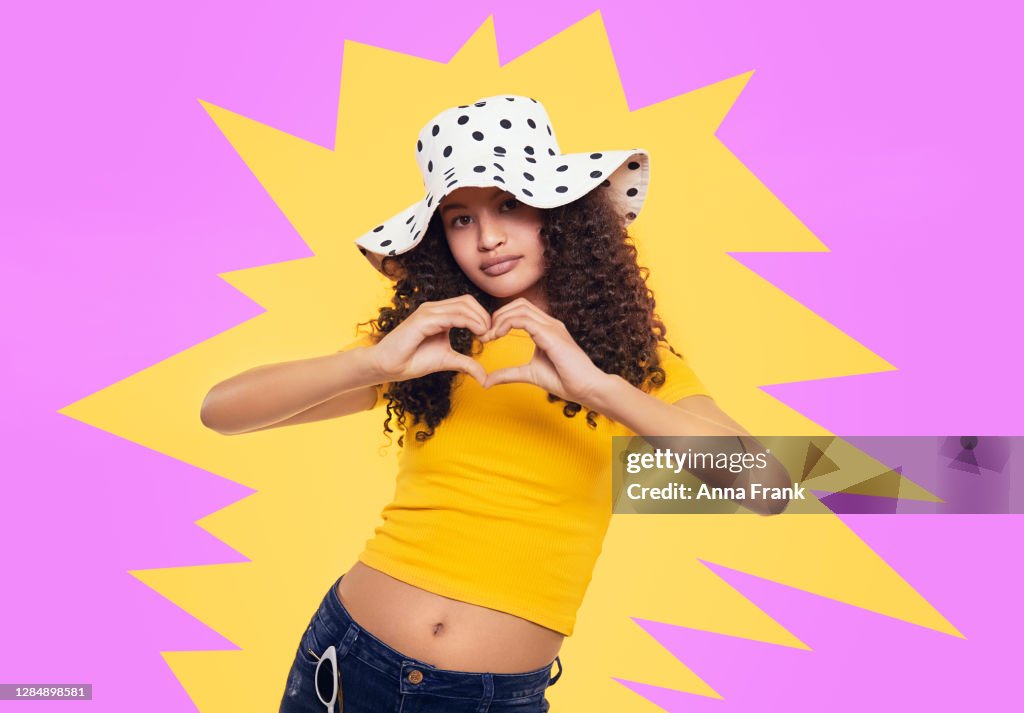 Beautiful quirky teenager showing heart with hands