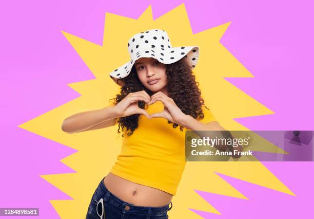 beautiful quirky teenager showing heart with hands - cute 15 year old girls stock pictures, royalty-free photos & images