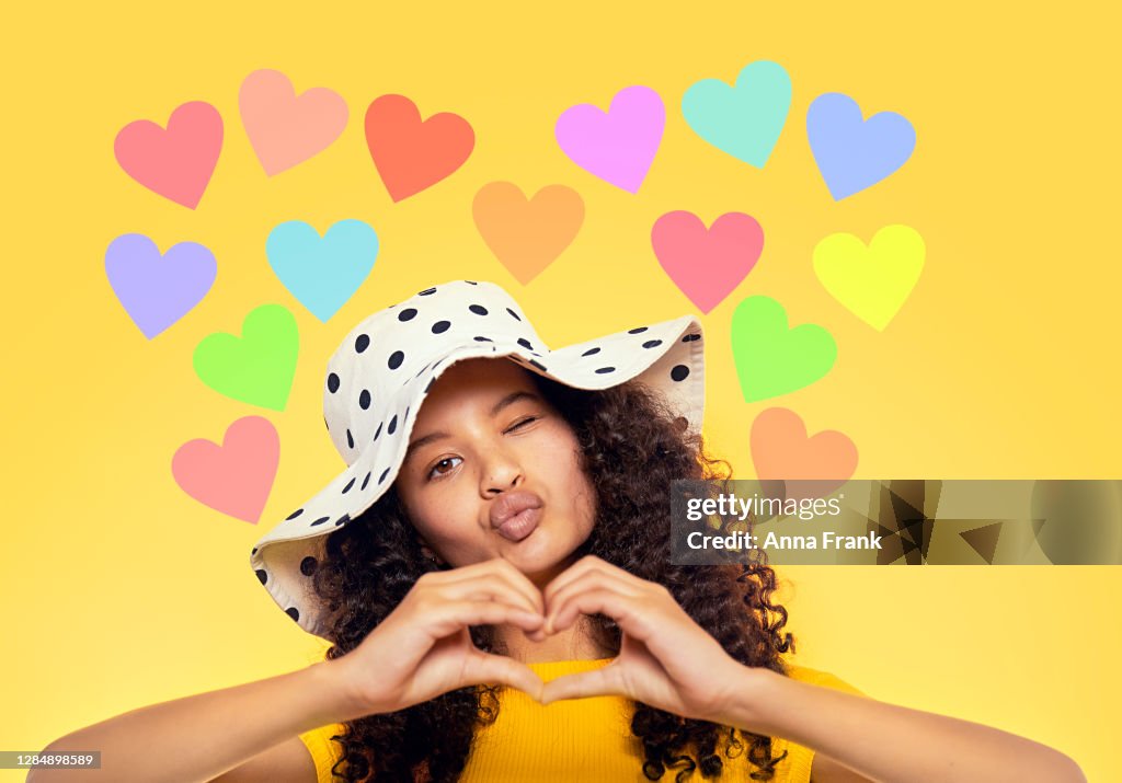 Beautiful mixed race teenager showing heart with hands