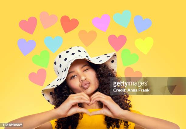 beautiful mixed race teenager showing heart with hands - cute 15 year old girls stock pictures, royalty-free photos & images