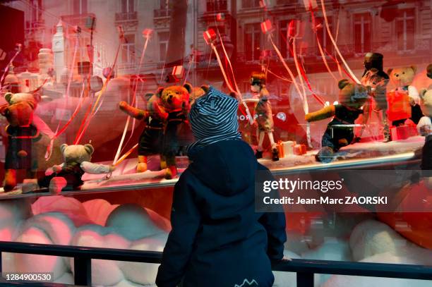 Un enfant émerveillé devant l'une des vitrines animées du Printemps, boulevard Haussmann, le 26 novembre 2017 à Paris, France.