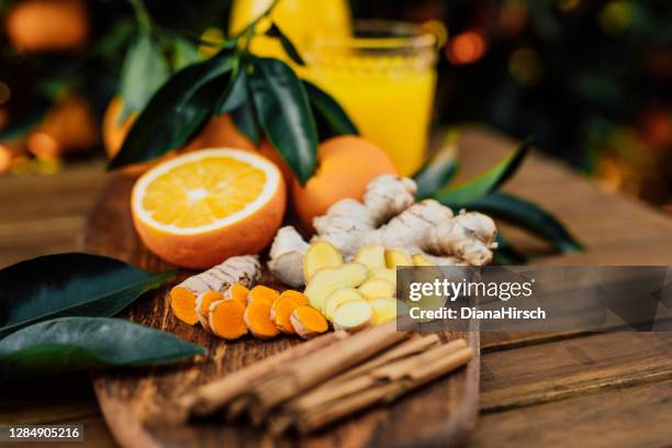 シナモンスティックと自分の庭から未処理のバイオオレンジの絞りたてのオレンジジュースとウコンとジンジャールート - ショウガ ストックフォトと画像
