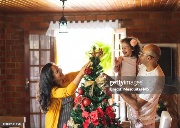 familie schmückt den weihnachtsbaum - chrismas brasil stock-fotos und bilder