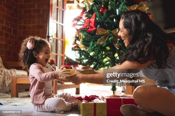 dando regalo de navidad - christmas gift fotografías e imágenes de stock