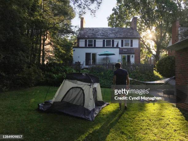 man setting up a tent in the backyard - nur erwachsene stock-fotos und bilder