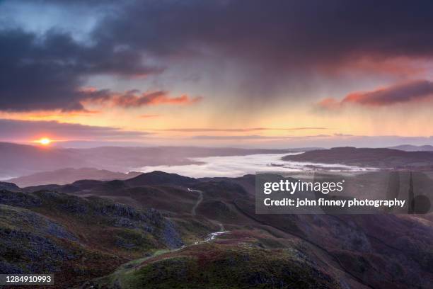 autumn rain showers at sunrise over lake windermere, lake district, uk - lake windermere stock-fotos und bilder