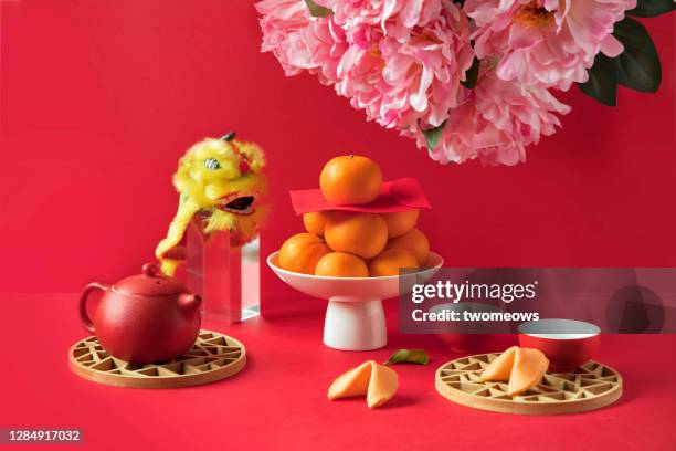 chinese new year food, mandarin oranges and tea set on red background. - chinese new year food stock-fotos und bilder