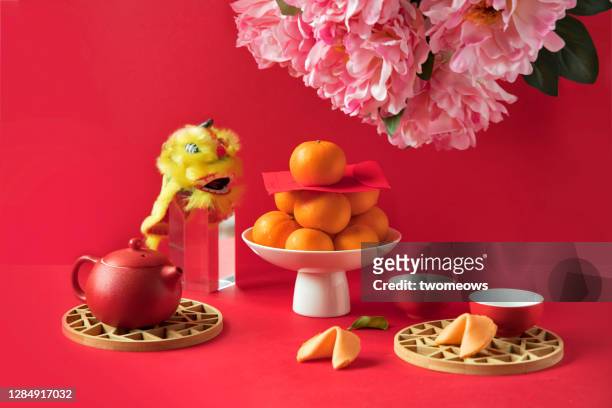 chinese new year food, mandarin oranges and tea set on red background. - chinese new year food stock pictures, royalty-free photos & images