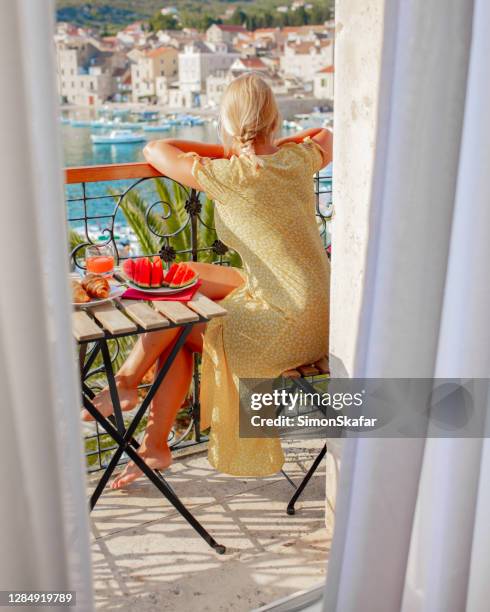 woman looking at town harbor from balcony, adriatic sea, croatia - luxury hotel room stock pictures, royalty-free photos & images