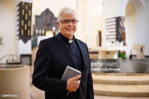 portrait of a happy pastor in church - christentum stock-fotos und bilder