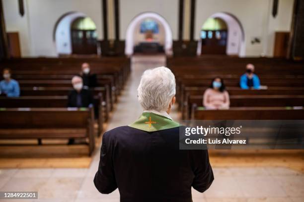 pastor praying for congregation - pastor stock pictures, royalty-free photos & images
