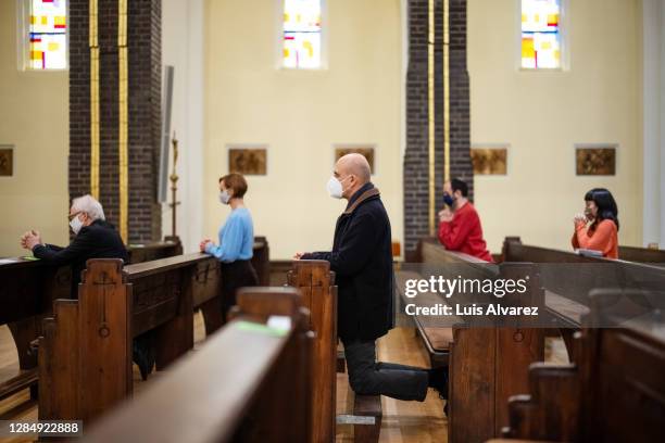 people respecting covid-19 restrictions during religions mass - prayer book fotografías e imágenes de stock