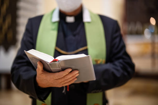 priest reading bible during congregation in church - pastor - fotografias e filmes do acervo