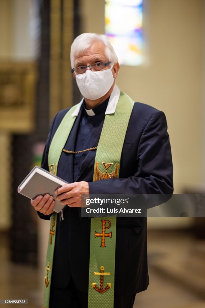 Church priest wearing protective face mask