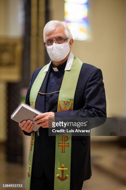 church priest wearing protective face mask - pastor stock pictures, royalty-free photos & images