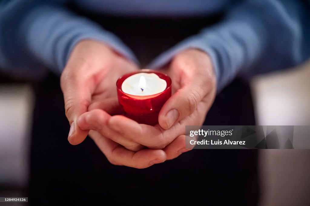 Close-up of woman holding a votive candle