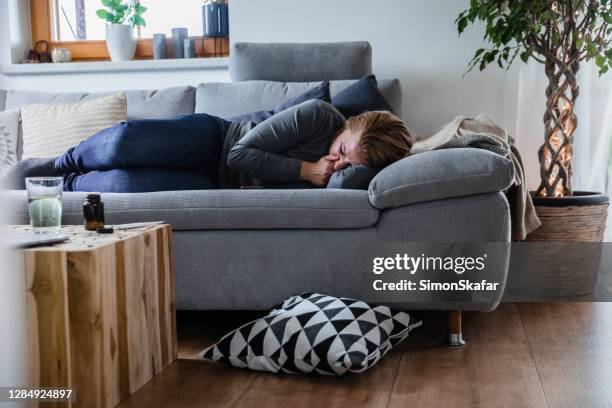 sick woman lying on the couch - vomit stock pictures, royalty-free photos & images