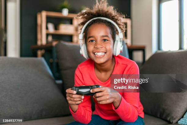 young girl playing video games at home - one teenage girl only stock pictures, royalty-free photos & images