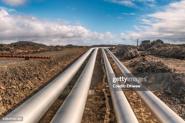 pipelines of hot water from natural hot springs in lava field area - conducto fotografías e imágenes de stock