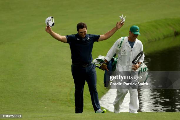 Jon Rahm of Spain celebrates with his Adam Hayes after skipping in for a hole in one on the 16th during a practice round prior to the Masters at...