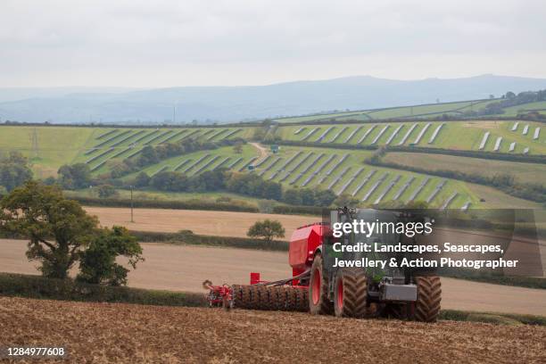 tractor drilling oats with seed drill - tractor harvest stock pictures, royalty-free photos & images
