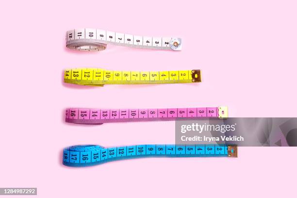 set of colored tapes measure on pastel pink background. - lunghezza foto e immagini stock