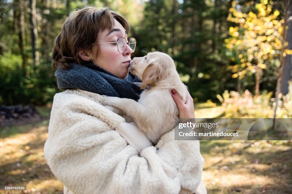 Junge Frau mit reinrassigen gelben flach beschichteten Retriever Welpen.