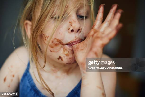 child with chocolate round her face - kids mess stockfoto's en -beelden