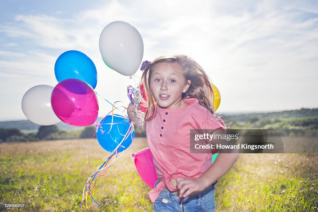 Female child running with balloons