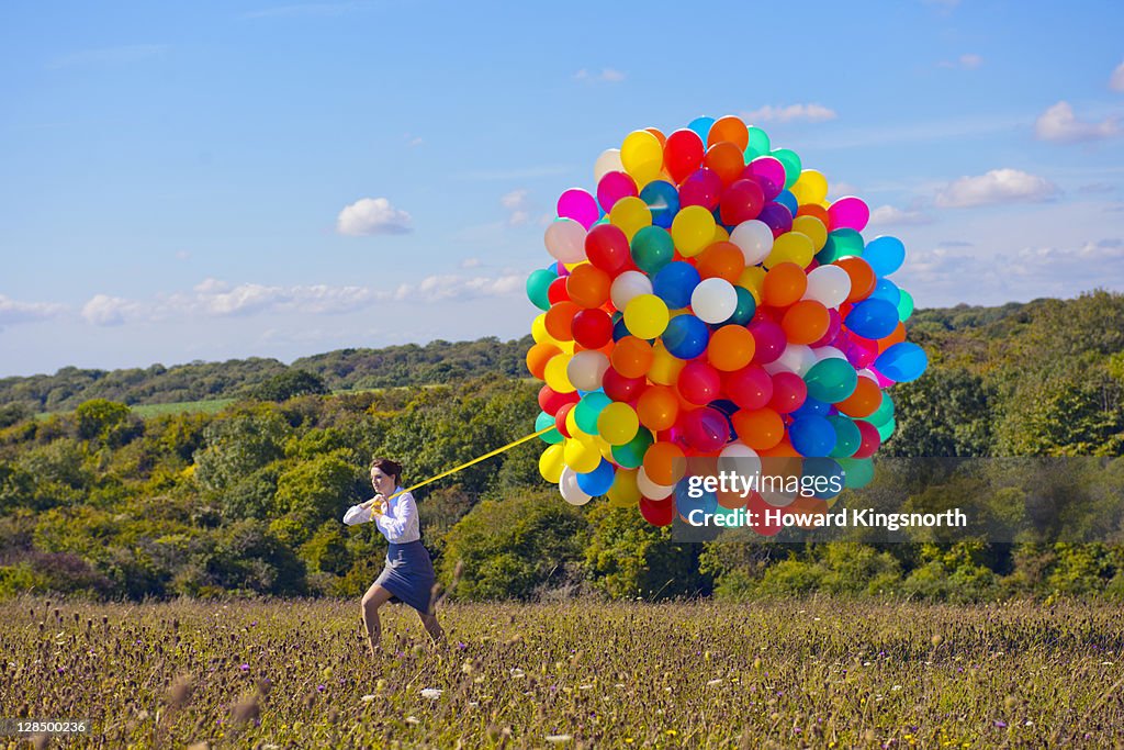 Business woman holding big bunch of balloons