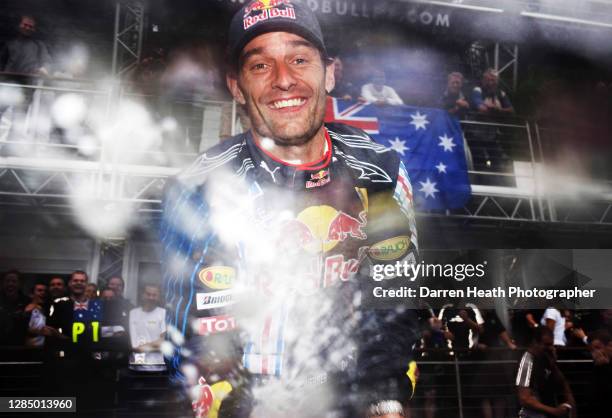 Australian Red Bull Racing Formula One driver Mark Webber celebrates with the whole of the Red Bull Racing team by spraying champagne after winning...