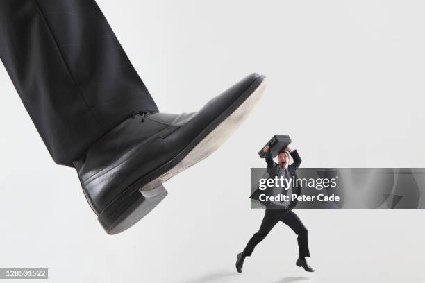 giant foot stepping on male executive - crush foot stock pictures, royalty-free photos & images