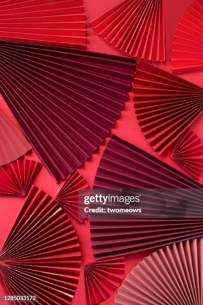 flat lay red paper fans background. - hand fan stock pictures, royalty-free photos & images