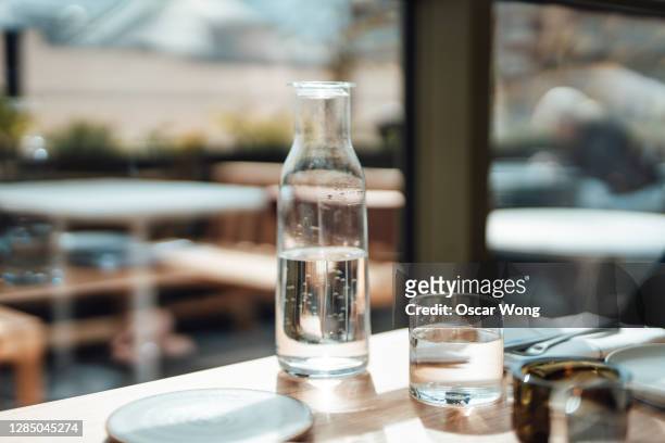 water jug and drinking glass on the wooden table in a restaurant - drinking glass of water stock pictures, royalty-free photos & images