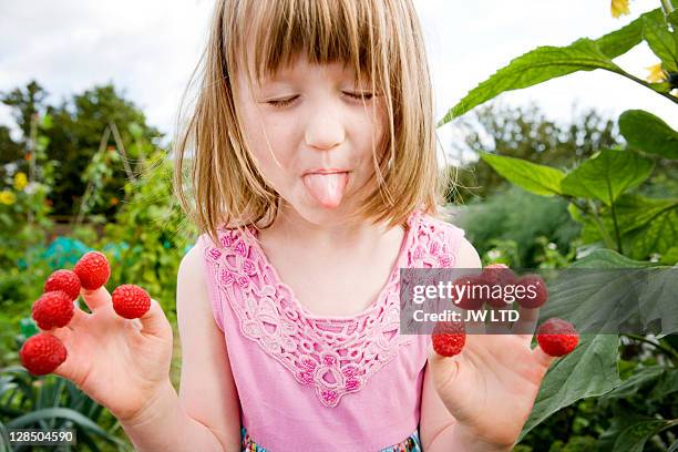 girl with raspberries on fingers, close up - local girls fotografías e imágenes de stock