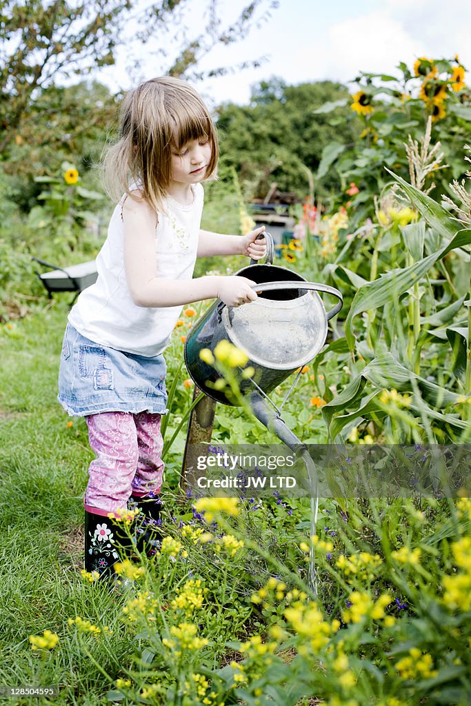 Girl watering plants outside