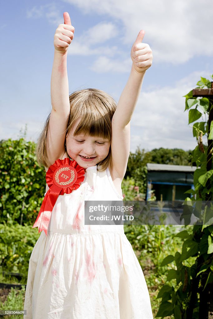 Girl wearing rosette with thumbs up