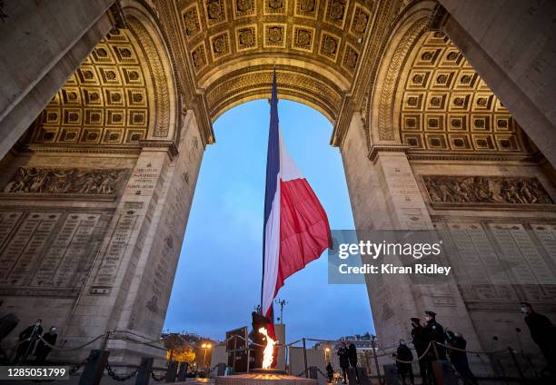 The French Tricolor Flag is raised above the Eternal Flame and the Tomb of the Unknown Soldier at the Arc de Triomphe as preparations begin for...