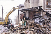 Demolition house. Building renovation at city. Industrial breaker