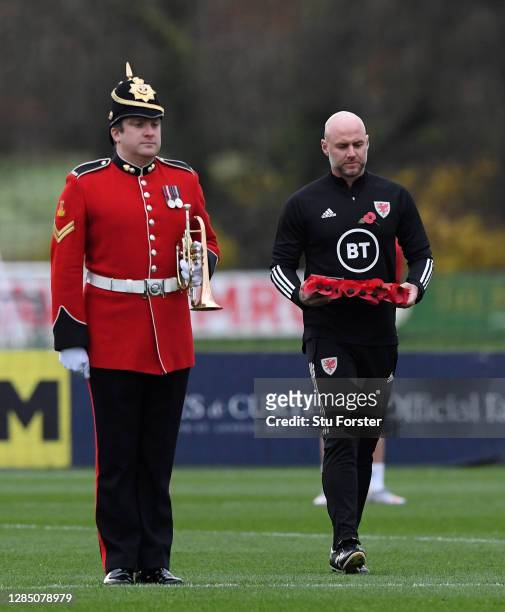 Wales coach Robert Page walks out onto the pitch to lay a wreath as the bugler looks on before a minutes silence for Remembrance day during Wales...