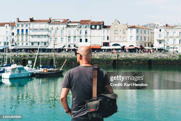 a man looks across the harbour, la rochelle - stock photo - charente maritime stock pictures, royalty-free photos & images