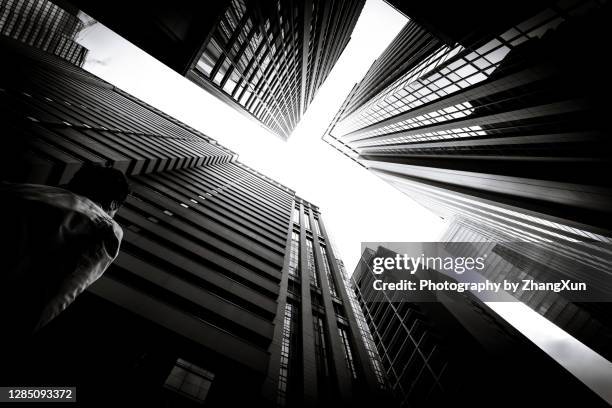 a man is looking up high rise office buildings, tokyo, japan. - toughness stock-fotos und bilder