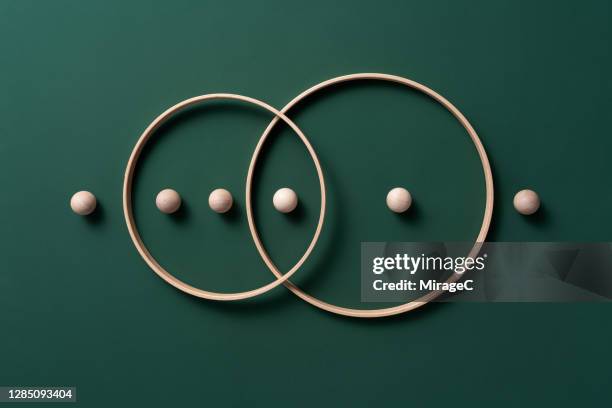 crossing rings with spheres - symbiotische relatie stockfoto's en -beelden