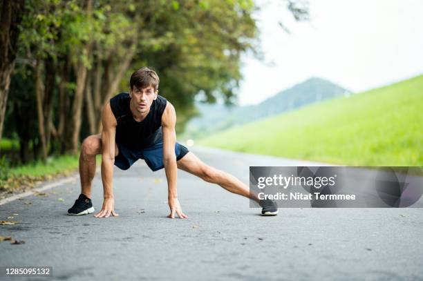 male athlete stretching, warming up the calf on a street after run or jogging. healthy, active lifestyle concept. - human body part stockfoto's en -beelden