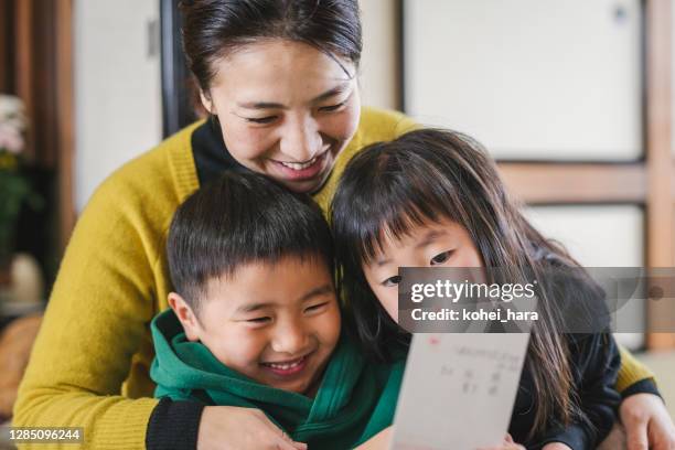 日本の母子が正月カードを読む - japanese family ストックフォトと画像