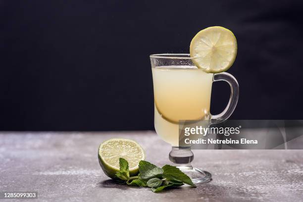 mojito with lime and mint in a cocktail glass on a gray background. refreshing drink in the summer heat - caipirinha stock pictures, royalty-free photos & images