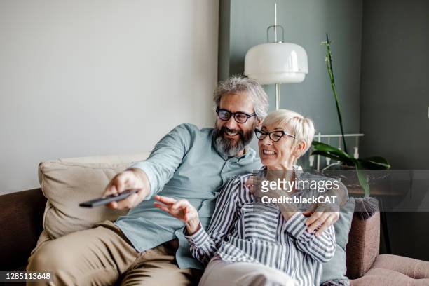 senior-paar zu hause vor dem fernseher - couple tv stock-fotos und bilder
