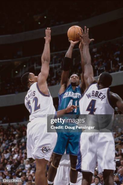 Glen Rice, Small Forward for the Charlotte Hornets shoots for the basket as Chris Webber and Terry Davis of the Washington Wizards attempt to block...