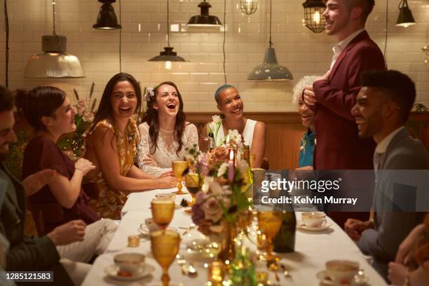 lesbian same sex wedding and friends having dinner party - warmes abendessen stock-fotos und bilder